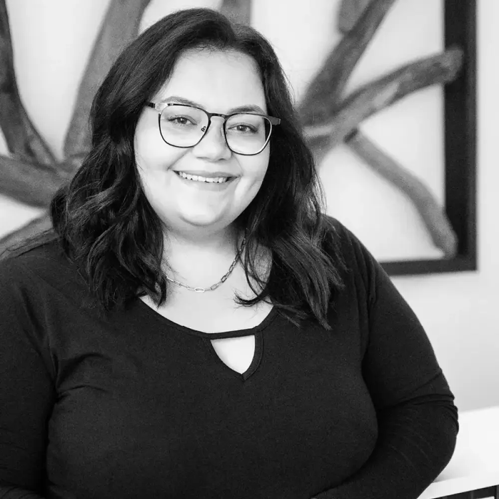 Lächelnde Frau mit dunklen Haaren und Brille im Büro von STUDIO S Architekten