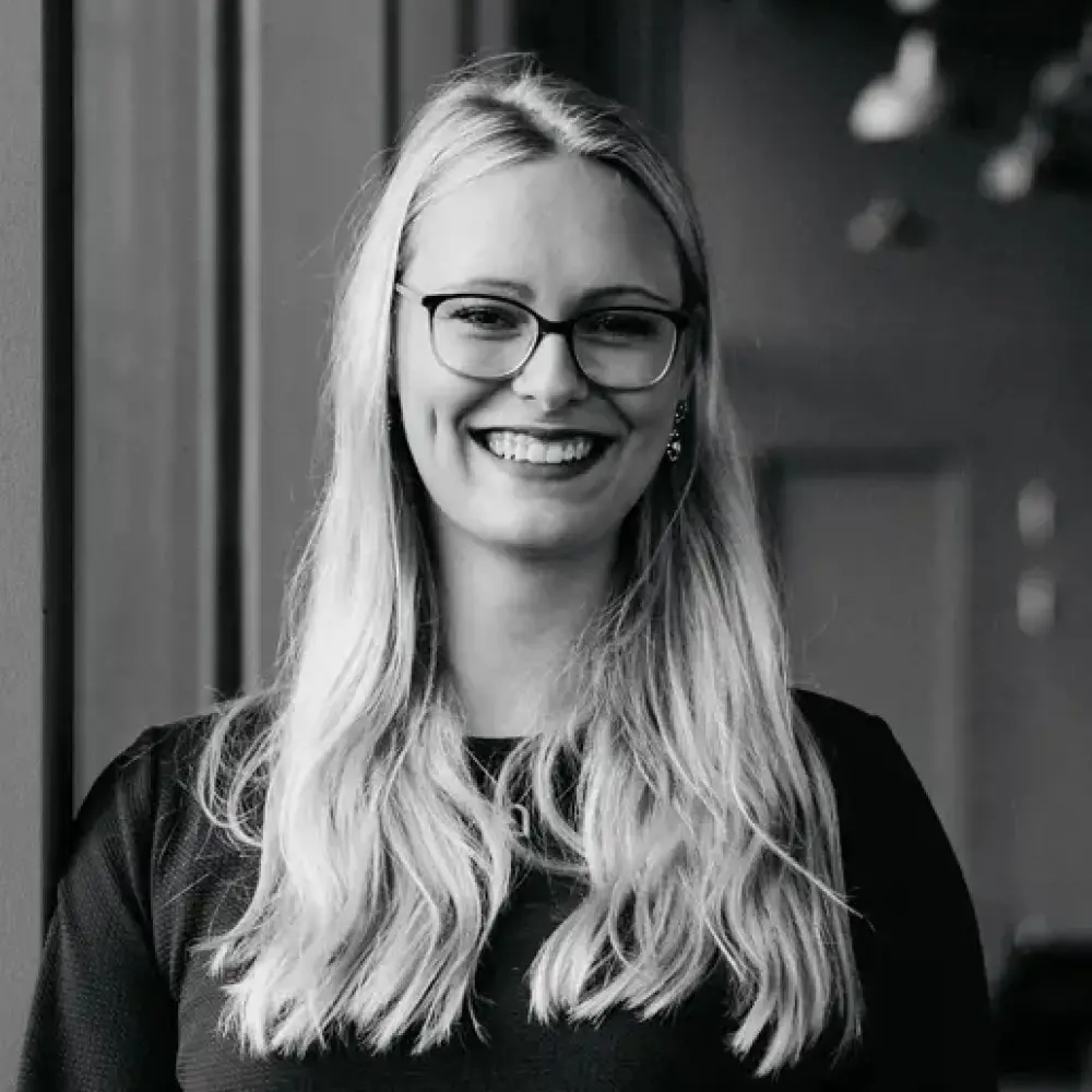 Lächelnde junge Bauzeichnerin mit langen blonden Haaren und Brille bei STUDIO S Architekten Bocholt